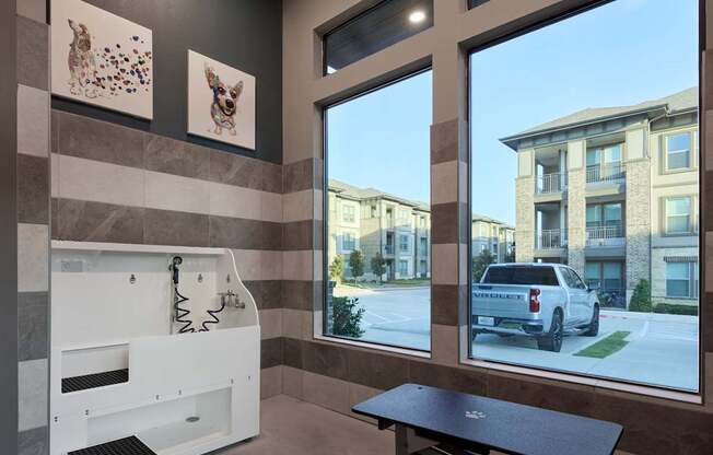 A bathroom with a bench and a window overlooking a street.