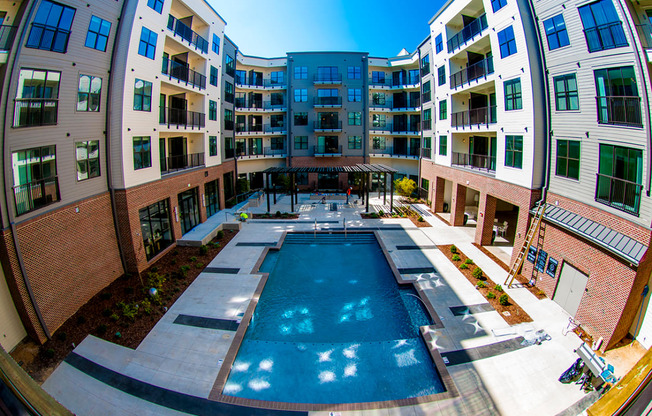 an apartment building with a pool in the middle of it