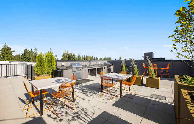 a patio with tables and chairs and a grill on a rooftop at Ion Town Center, Shoreline Washington