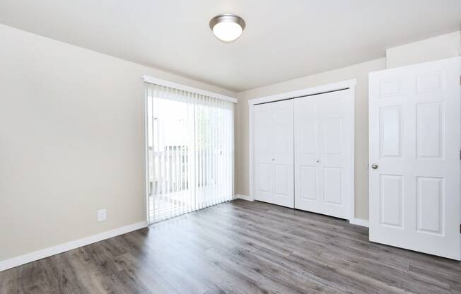 an empty living room with white walls and wood flooring