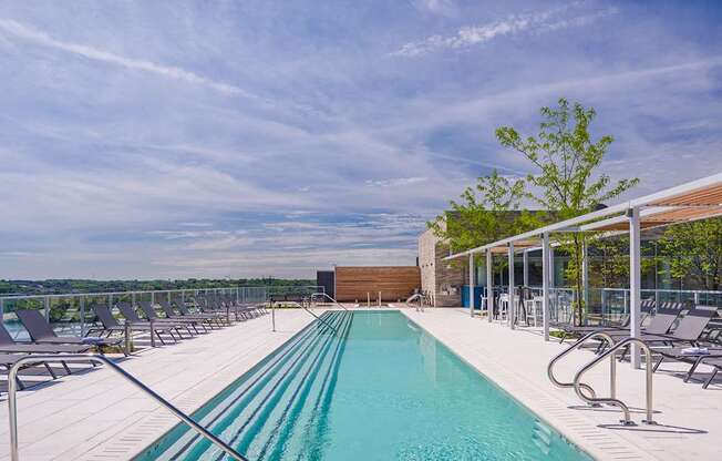 A large outdoor swimming pool with lounge chairs and a view of the horizon.