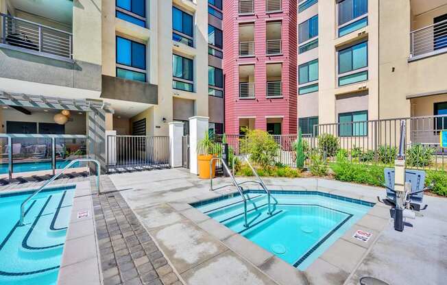 A swimming pool in a courtyard surrounded by buildings.