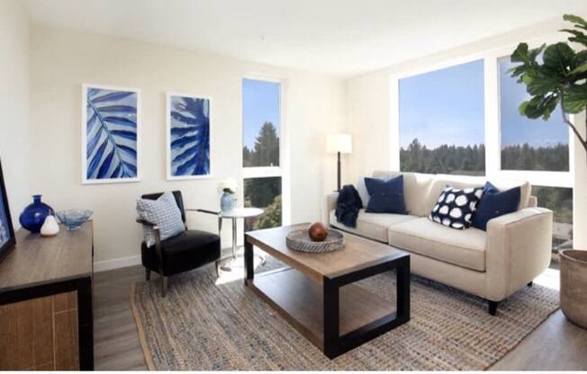 Living Room with plank flooring, spacious living room rug, and large floor-to-ceiling living room windows at Arabella Apartment Homes, Shoreline, 98155