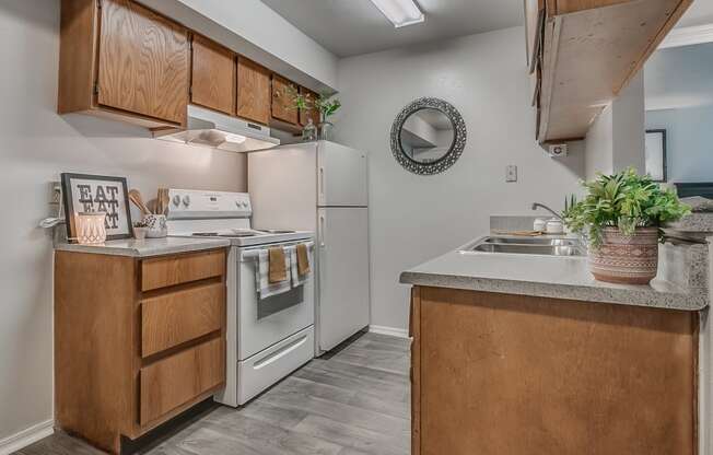 Galley Kitchen With White Appliances & Wood-Style Flooring