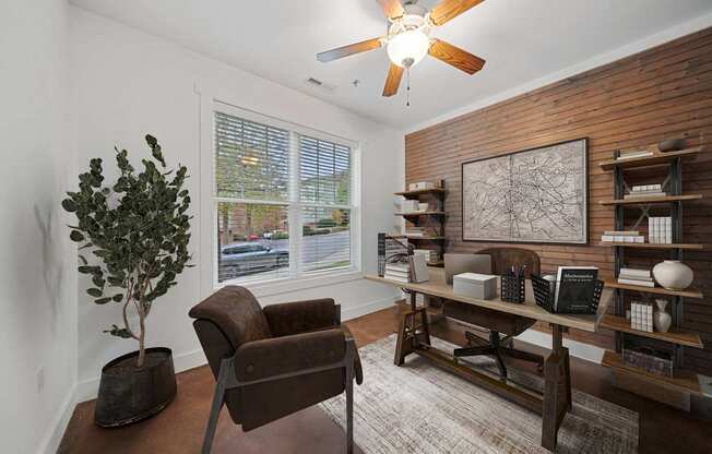 A living room with a brown chair and a tree in a pot at River Mill Lofts & Skyloft in NC 28803