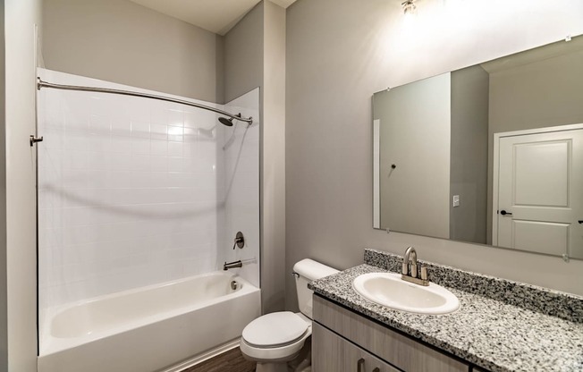 A white bathroom with a sink, toilet and bathtub.