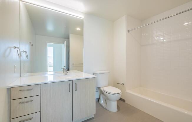 A white bathroom with a toilet, sink, and bathtub.
