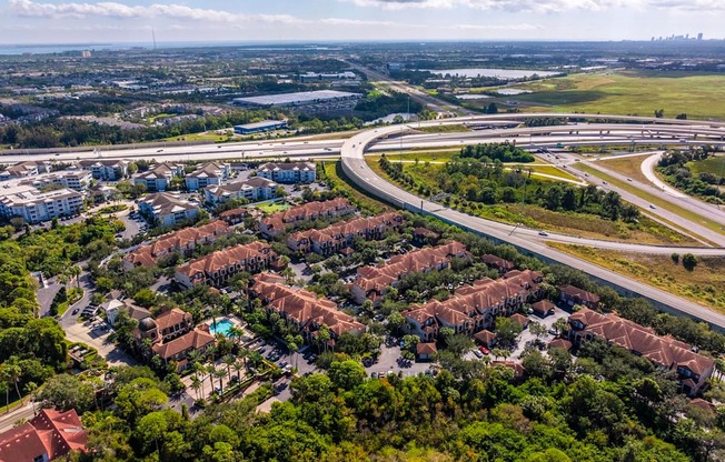 Overhead view of community surrounded by trees and connecting roadways
