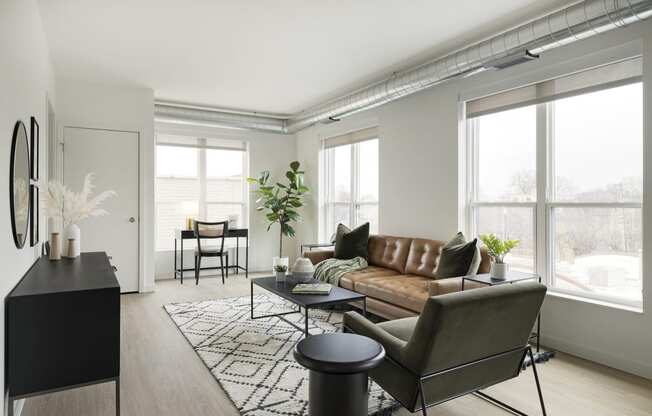 a living room with a brown leather couch and a black coffee table