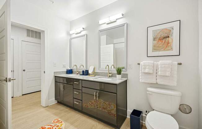a bathroom with a sink and a toilet and a mirror at Link Apartments® Calyx, North Carolina