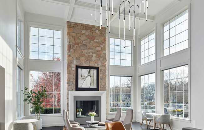 A living room with a stone fireplace and a large window.