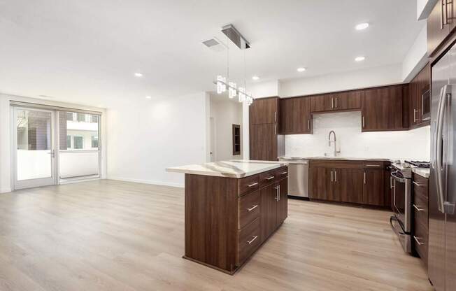 A modern kitchen with wooden cabinets and stainless steel appliances. at Elements Apartments*, Irvine, California