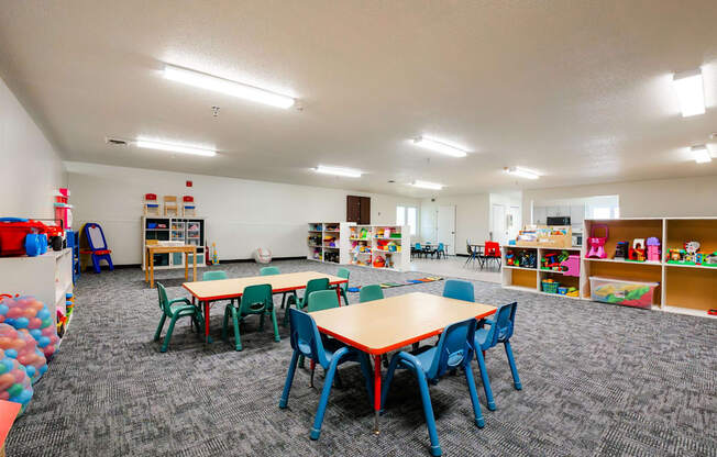 a preschool classroom with tables and chairs and toys at Sutton Hill Apartments, Des Moines, IA