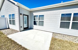 A house with a grey siding and a white door and windows.