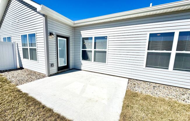 A house with a grey siding and a white door and windows.