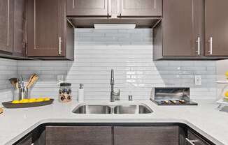 a white kitchen with wooden cabinets and a sink