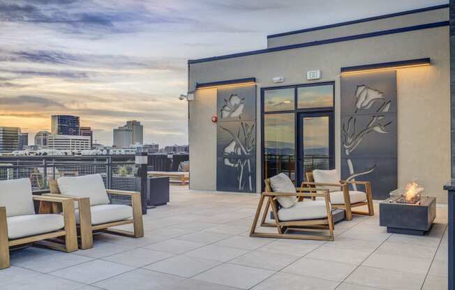 a roof deck with chairs and a view of the city