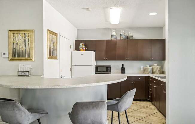 A kitchen with a white counter and brown cabinets.
