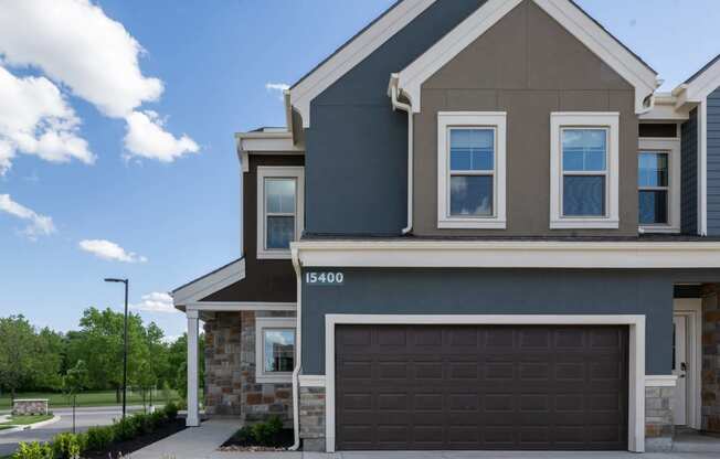 a home with a garage door in front of it at The Clearing at ONE28, Olathe, KS