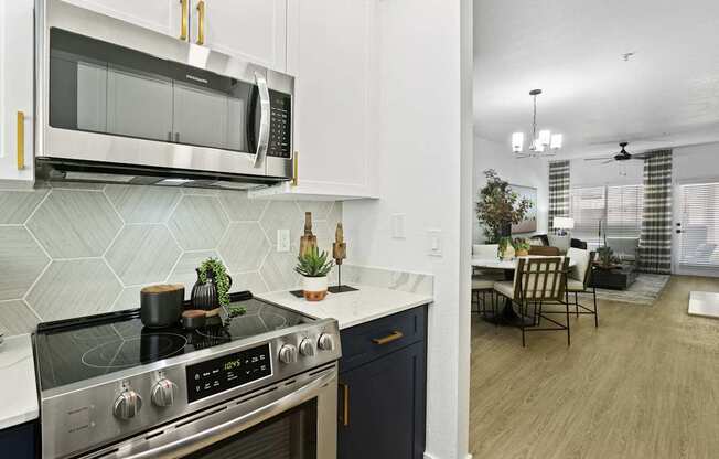 A modern kitchen with a stove top oven and microwave above it.