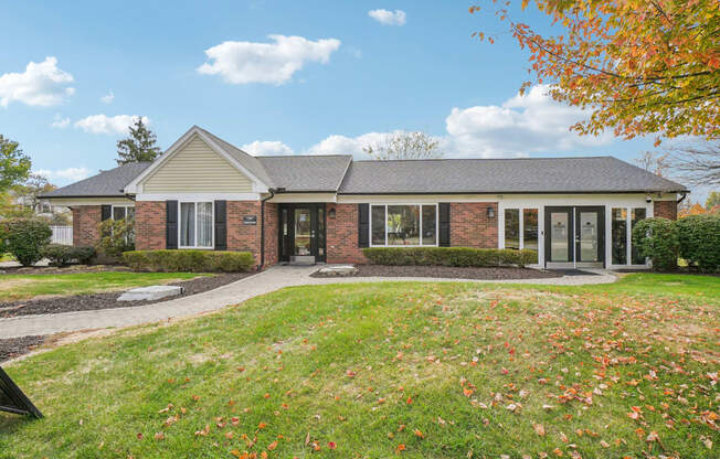 A house with a lawn and trees in the background.