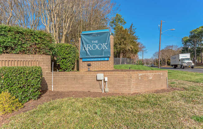 A sign that says "The Brook" is mounted on a wall.
