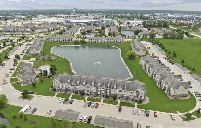 drone view of scenic community with pond fountains at Hunters Pond Apartment Homes, Champaign, 61820