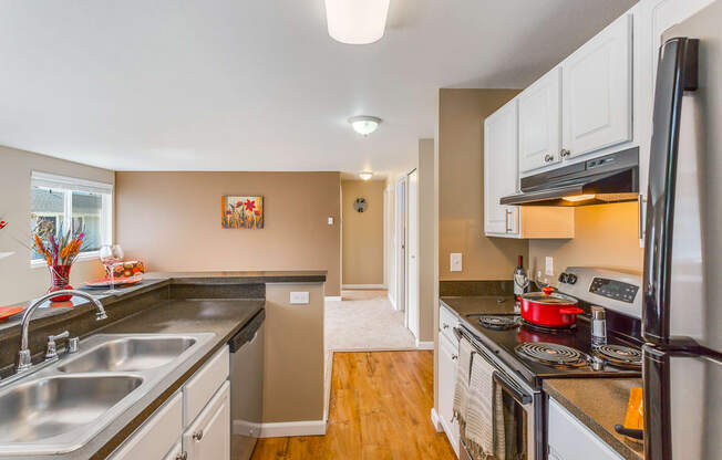 a kitchen with a stove and a sink and a refrigerator at Springfield, Washington, 98055 