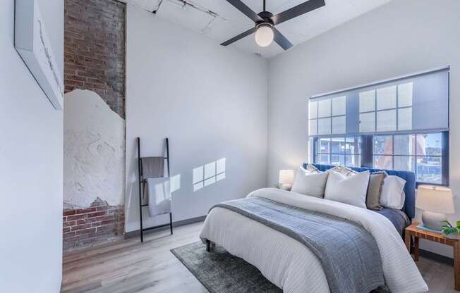 A bedroom with a large bed and a ceiling fan.