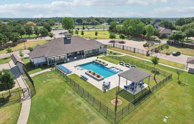 an aerial view of a swimming pool in front of a house