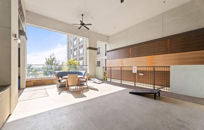 A room with a table and chairs and a fan.