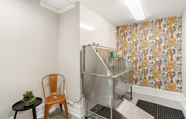 a small kitchen with a stainless steel refrigerator and two chairs at Lagniappe of Biloxi Apartment Homes, Mississippi   , 39532