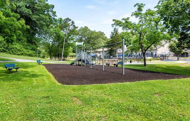 a playground with a swing set and benches in grassy area