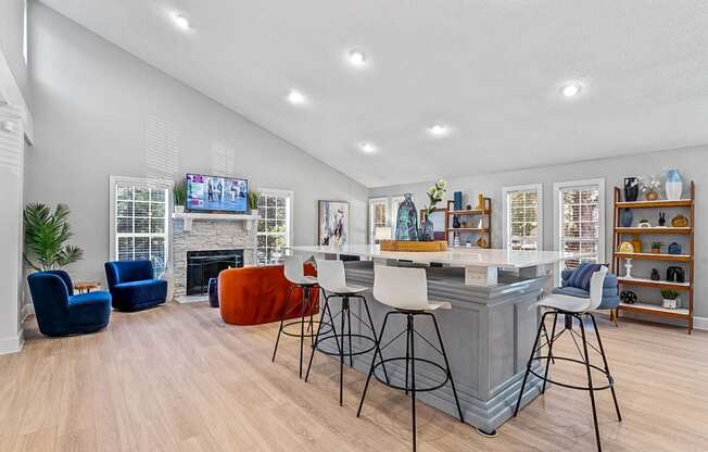 a living room with a fireplace and a bar with stools