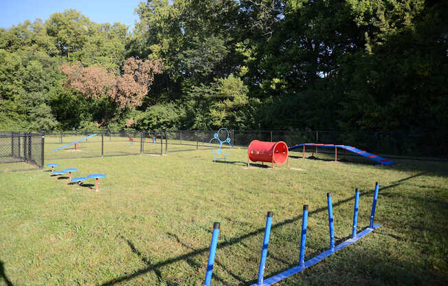 A playground with a blue fence and a red slide.