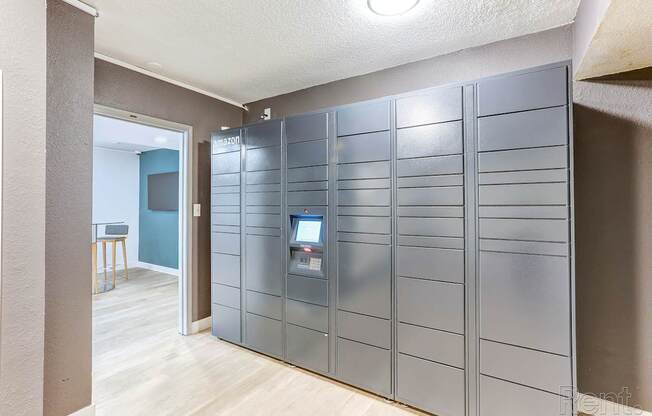 A room with a grey wall and a grey locker with a computer on it.