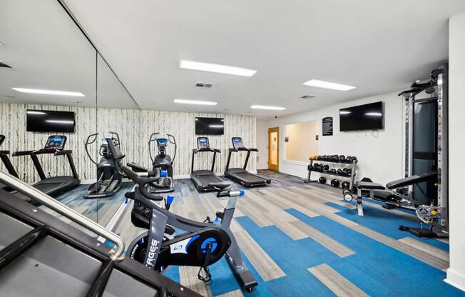 a gym with cardio equipment and a tv on the wall at Chapel View Apartments in Chapel Hill, NC