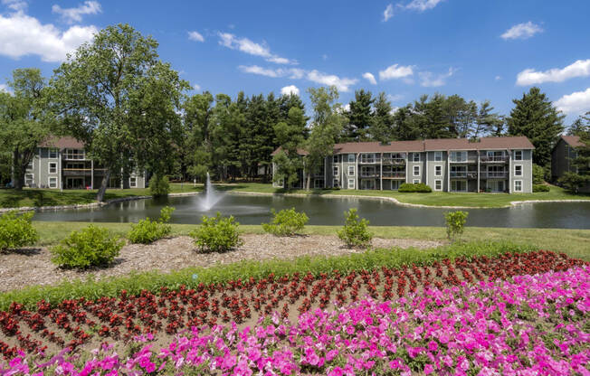 a view of a pond with flowers in front of a building