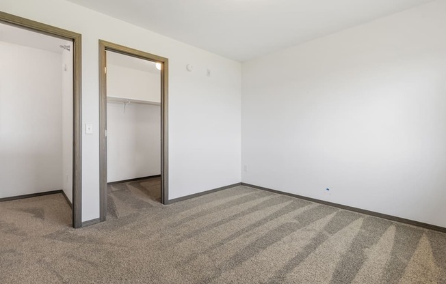 A room with a striped carpet and two open doors.