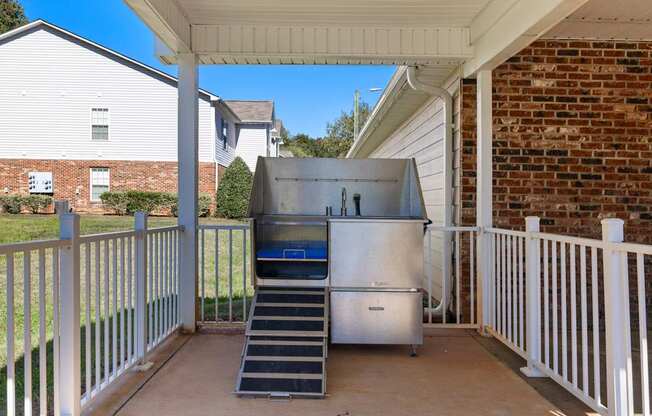 A stainless steel refrigerator is on a patio.