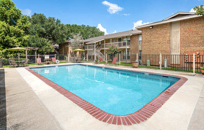 A swimming pool surrounded by a fence and trees.