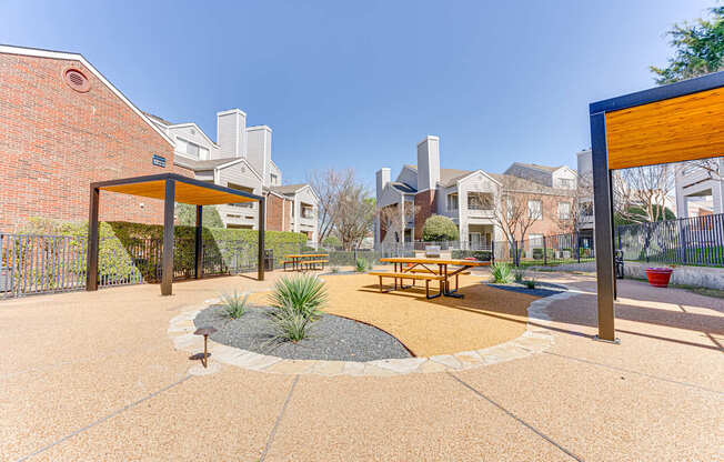 A small outdoor patio with a picnic table and a fire pit.