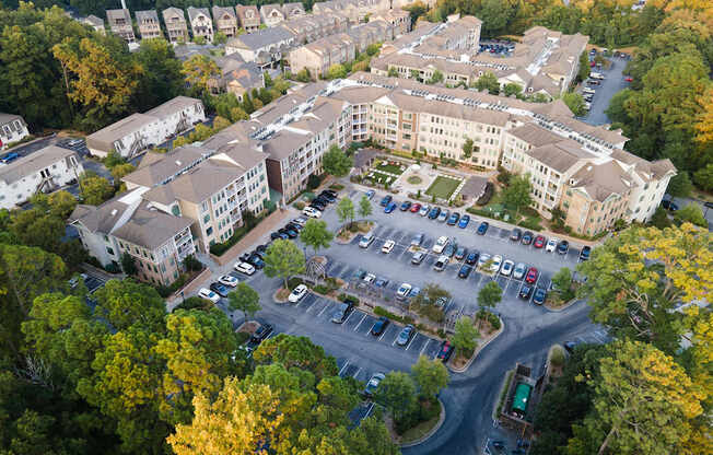 An aerial view of a parking lot surrounded by buildings and trees.
