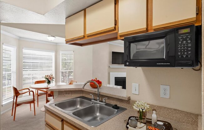 a kitchen with a sink and microwave in a 555 waverly unit