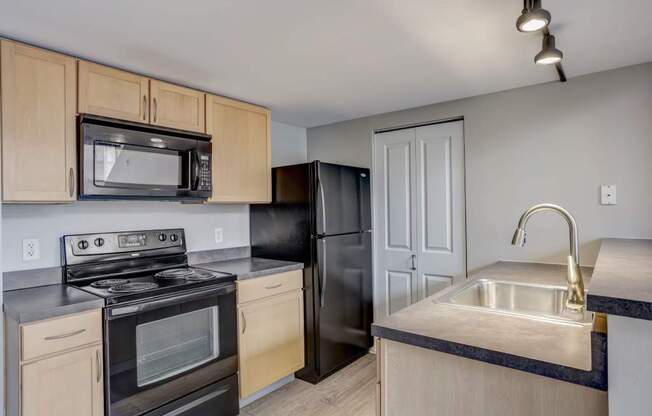 a kitchen with a stove refrigerator and sink