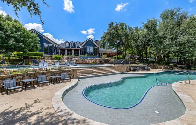 a swimming pool with chairs and a house in the background at The Vista on Brodie, Texas, 78745