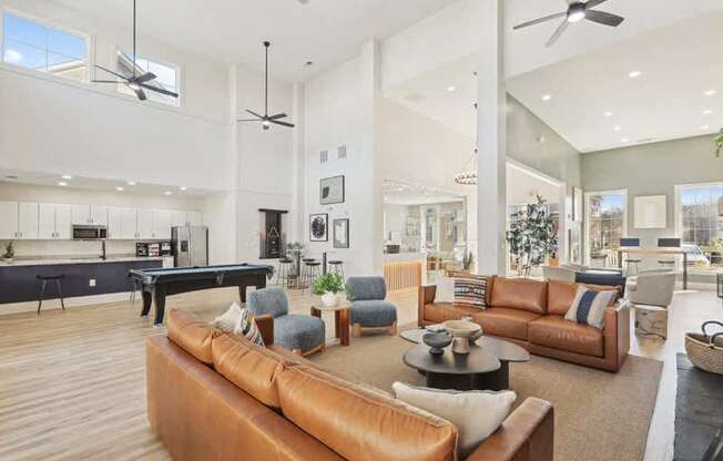 A modern living room with a pool table and a variety of seating options.