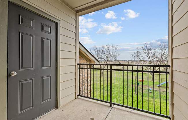A view from a doorway looking out to a fenced yard.