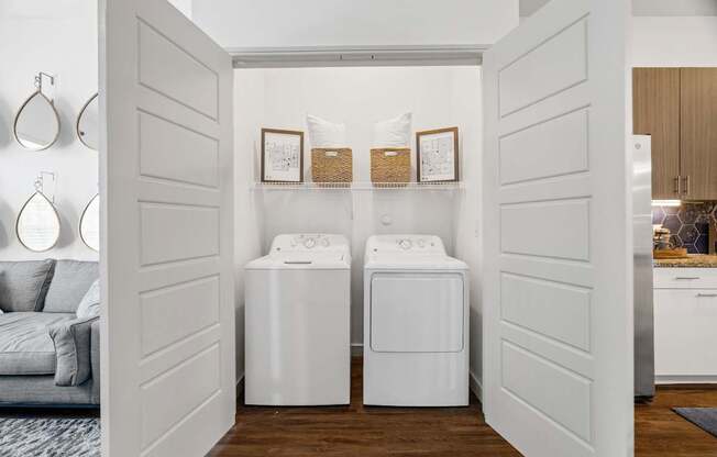 A laundry room with two washing machines and a shelf above them.