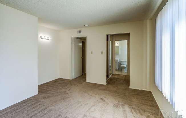 a living room with white walls and a brown carpet at Terrace View Apartments, California